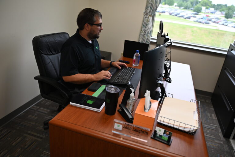 John Laughrin, founder and president of Four Leaf Communications, working at his desk in Green Bay, Wisconsin office.