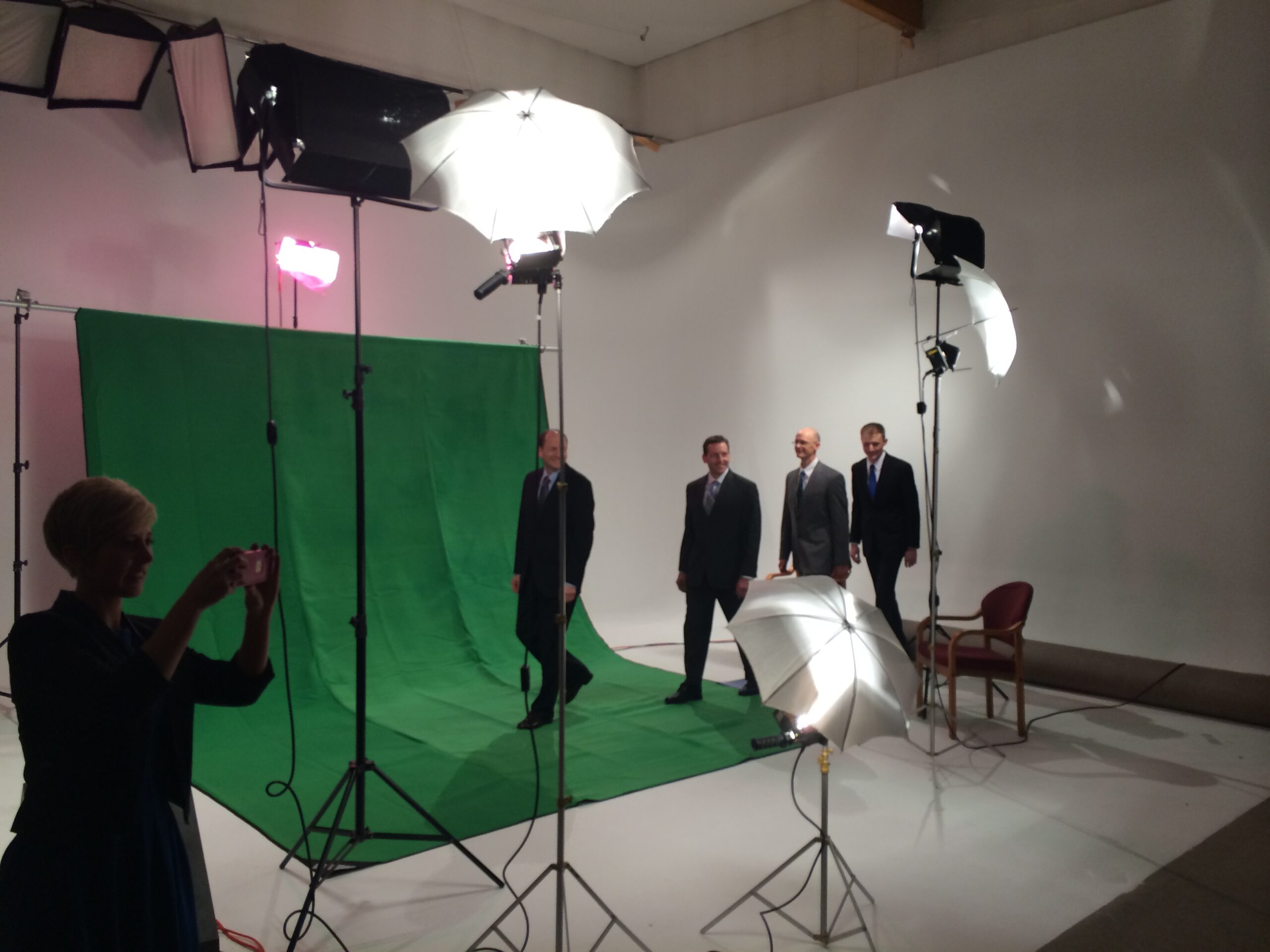 Studio lighting setup with green screen and video equipment during a commercial production.